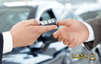 Handing car keys to a satisfied used car buyer at Lava Automotive